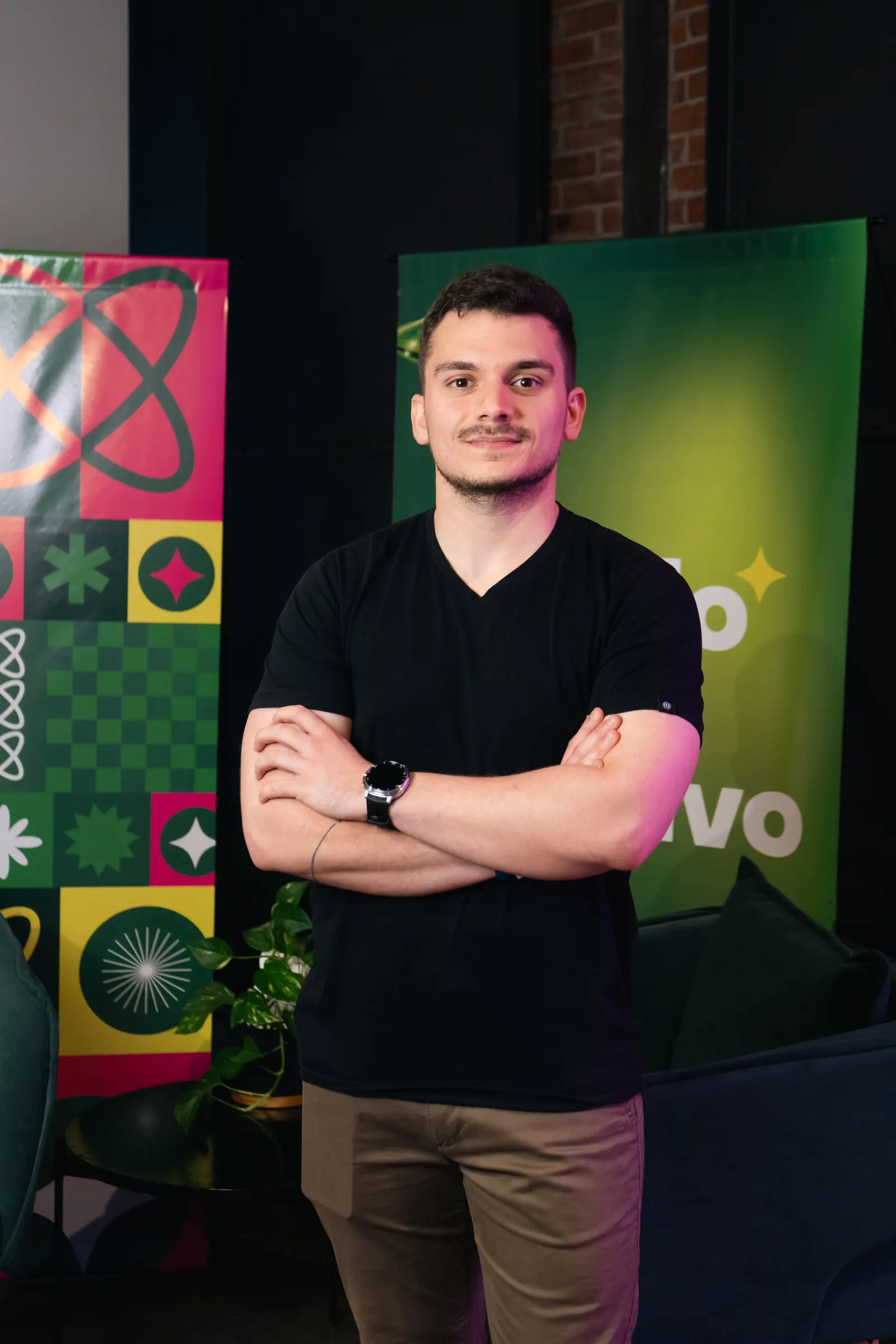 Retrato de Fran Blasich, de brazos cruzados, frente a banners de colores.